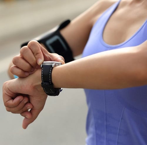 A woman looks at her smartwatch.